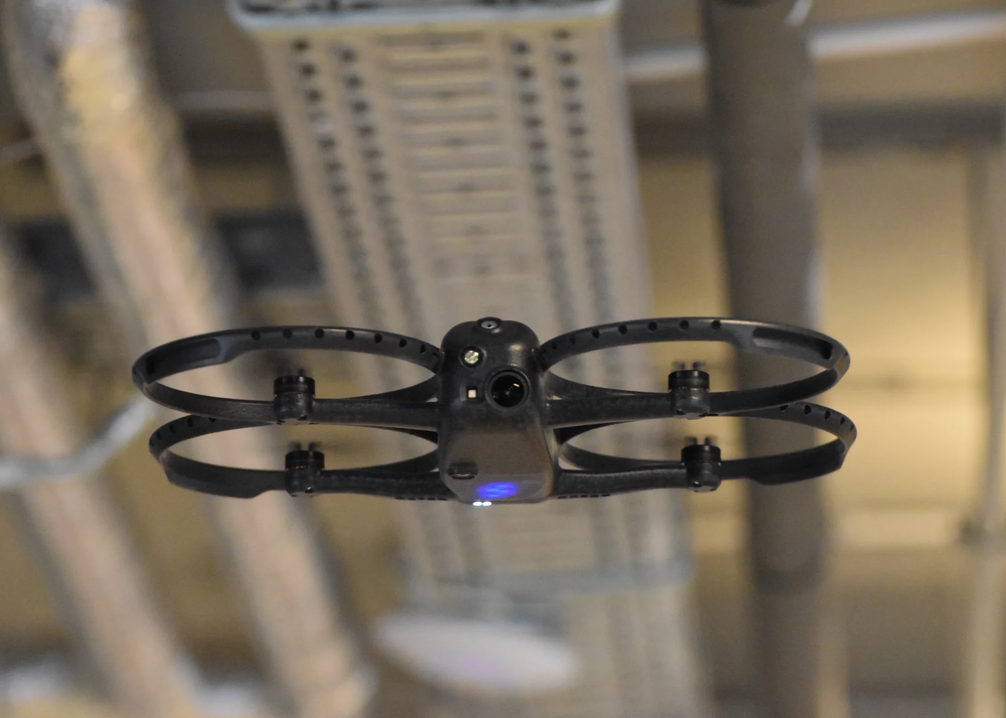 Corax flying below indoor industrial infrastructure